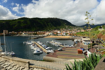 Machico, Madeira island, Portugal. Picturesque marina and rolling hills of a small town.