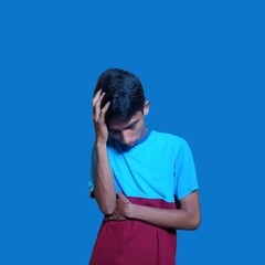 dizzy young asian man holding head, wearing blue t-shirt isolated blue background.