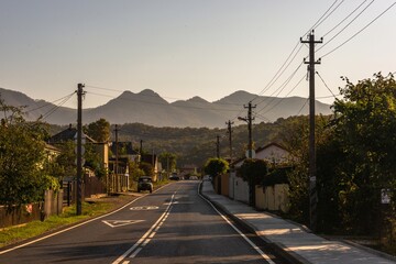 asphalt road with markings along the street with one-story houses in a small village in the mountains of the Western Caucasus on a sunny late summer day