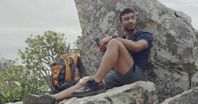 Phone, rock and man relax on mountain climbing journey, travel exercise or morning cardio training. Nature, trekking break and person rest after hiking, workout and check fitness app on cellphone