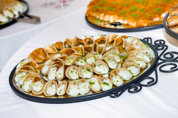 Qatayef, a traditional Arabic dessert with cream and pistachio 