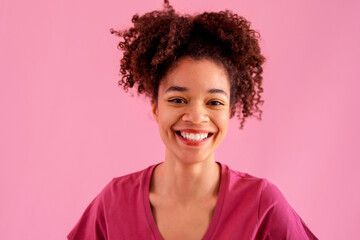 Attractive smiling female african american with sincere beautiful smile on pink background.