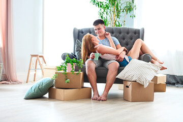 Young happy couple in room with moving boxes
