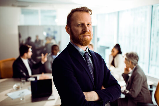 Portrait of a young successful businessman in busy office