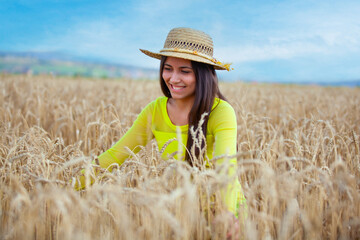 young girl in a hat in a wheat field - 714840701