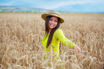 young girl in a hat in a wheat field - 714840719