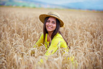 young girl in a hat in a wheat field - 714840757