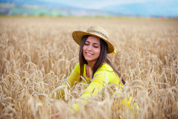 young girl in a hat in a wheat field - 714840792