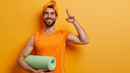 Young fitness trainer instructor sporty man sportsman wear orange t-shirt hold in hand yoga mat show thumb up training in home gym isolated on plain yellow background. Workout sport fit abs concept. - obrazy, fototapety, plakaty