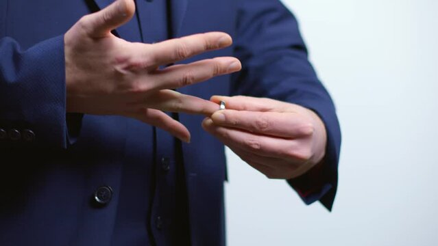 Man removing his wedding ring. Business person in a suit taking of traditional jewelry. Preparation before cheating on his wife.