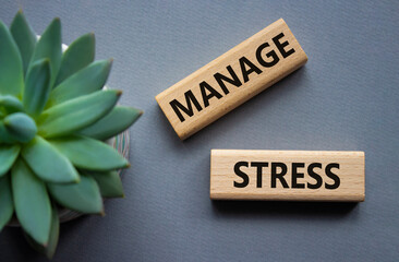 Manage stress symbol. Concept word Manage stress on wooden blocks. Beautiful grey background with...