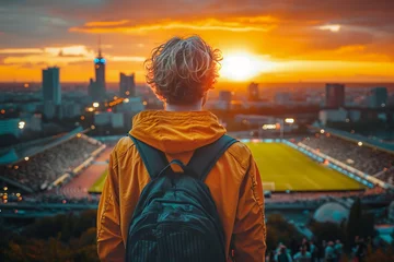 Tuinposter Back view of a male fan in a football stadium with a backpack © michaelheim