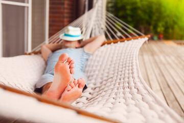 Man in hat in a hammock on a summer day
