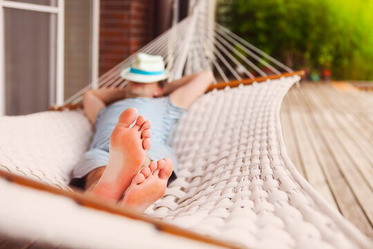 Man in hat in a hammock on a summer day