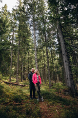 Naklejka na ściany i meble family young couple in the mountains, autumn forest. a man and a woman went to the mountains. clothes and shoes for trekking. Man and a woman went on a mountain trip. CARPATHIAN MOUNTAINS
