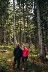 Obraz premium family young couple in the mountains, autumn forest. a man and a woman went to the mountains. clothes and shoes for trekking. Man and a woman went on a mountain trip. CARPATHIAN MOUNTAINS