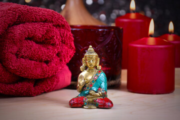 Zen spa still life with a buddha statue, red towel and candle stock photo images. Red spa and wellness setting with towels, candles and buddha statue. Beauty spa treatment composition images