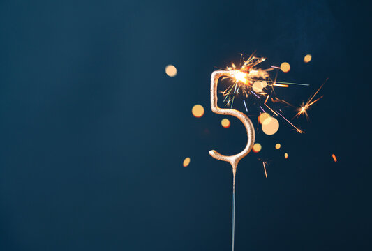 5 years celebration festive background with copy space made with Bengal fire in the form of number Five.