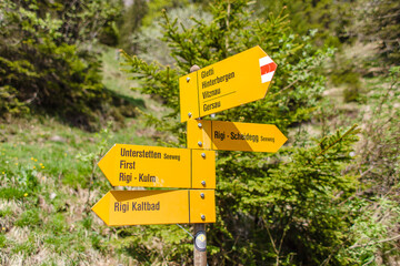 Yellow hiking trail signs in Switzerland at Mt. Rigi in the Swiss Alps