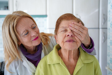 An ophthalmologist covering an old woman's eye