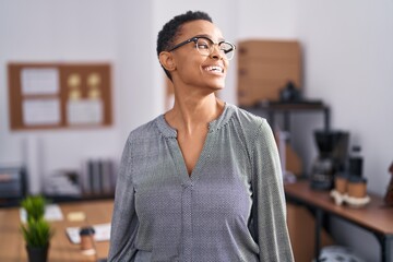 African american woman working at the office wearing glasses looking away to side with smile on...