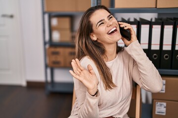 Young beautiful hispanic woman ecommerce business worker talking on smartphone at office