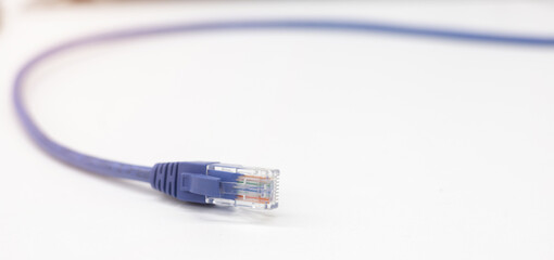 close up on blue RJ-45 Lan cable on white table for connecting to computer port or laptop to use internet network for technology concept