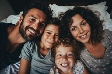 Portrait of a happy family smiling in bed - obrazy, fototapety, plakaty