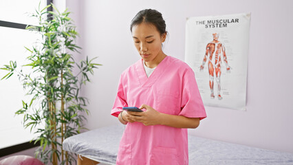Young asian woman healthcare professional using smartphone in clinic