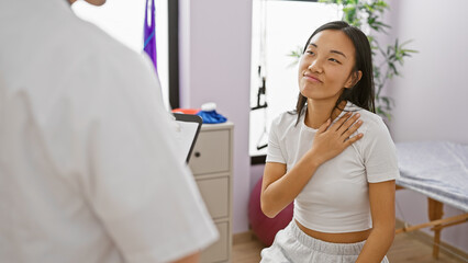 A woman patient expressing discomfort to a doctor at a physiotherapy session indoors.