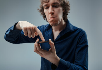 Distrustful expression while skeptically holding a smartphone
