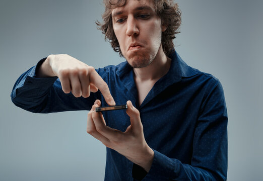 Distrustful expression while skeptically holding a smartphone