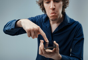 Disapproving glance at smartphone, mistrusts technological advan