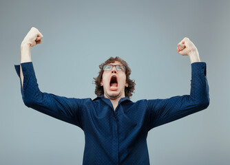 Triumphant exclamation, curly-haired man celebrates success loud