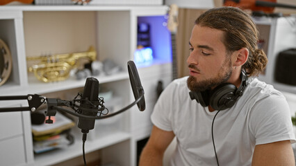 Young hispanic man musician singing song at music studio