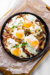 Fried eggs and meat on a frying pan