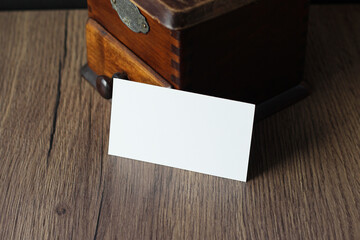 Blank business card mockup with vintage coffee grinder on wooden table background. Mock up for...
