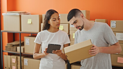 Man and woman, two determined workers, working together seamlessly on a laptop at their quaint indoor office - package preparation in full swing