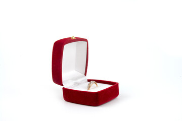 Gold ring with precious stones in a red gift box. An isolated object on a white background. A surprise, a gift, a present.
