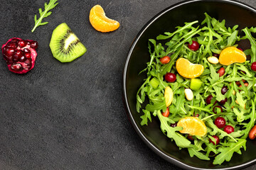 Fruit salad with arugula, tangerines and pomegranate seeds