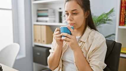 Early morning, the young, vivacious, and beautiful hispanic woman worker, savors her piquant...