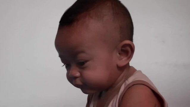 The Asian baby boy nine months old chews teether toys while playing alone at home