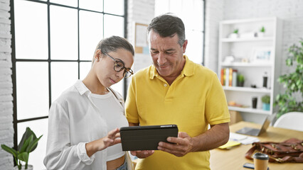 Man and woman business workers using touchpad working at the office