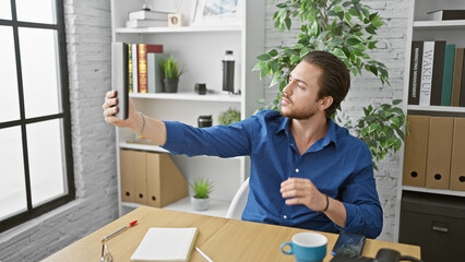 Young hispanic man business worker make selfie by touchpad at the office