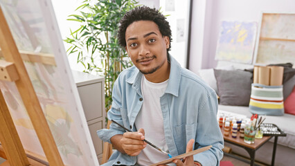 Portrait of a creative young man painting in a bright art studio, showcasing his artistic talent...