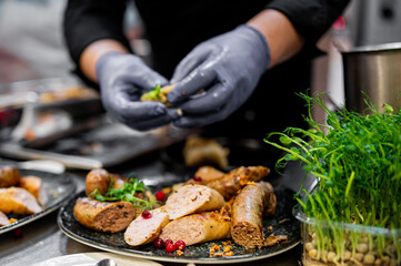 chef hand cooking sausages in the kitchen of a restaurant 