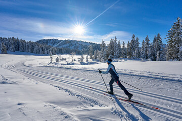 nice and active senior woman cross-country skiing in the  Hochhaedrich area of Bregenz Forest in...