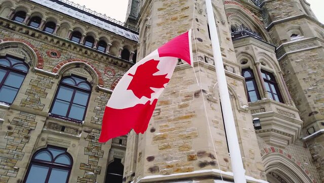 The national flag of Canada flies against the background of the East Block building, one of the three buildings on Canada's Parliament Hill, in Ottawa, Ontario.