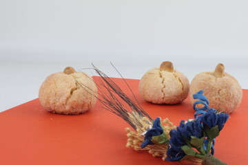 Tipici biscotti sardi morbidi con composizione floreale e sfondo colorato minimalista.