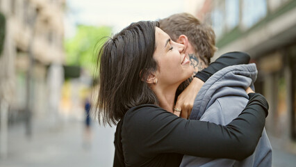 Obraz premium Beautiful couple smiling confident hugging each other at street